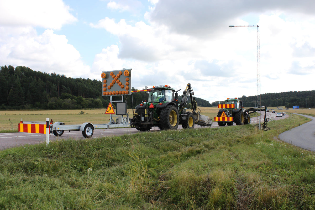 Trailer truck mounted attenuator with LED arrow board deployed at a roadside work zone